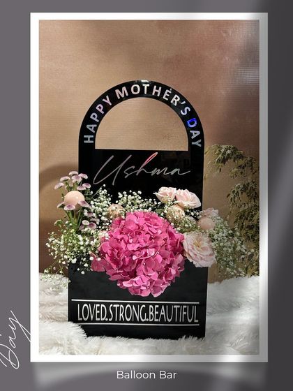 A stylized shot of our personalized "Posy Purity Purse." The sleek black design with custom engraving makes it a modern and sophisticated floral gift for the stylish mom.