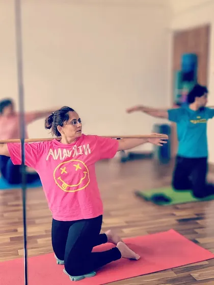 A student in my workshop using the stick for support in a kneeling twist. This variation helps to open up the chest and shoulders while maintaining stability and proper spinal alignment.