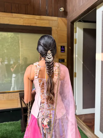 The back view of a gorgeous fishtail paranda braid. The pearl accessory at the top adds a touch of elegance, while the long, flowing braid gives that classic Indian bridal feel.