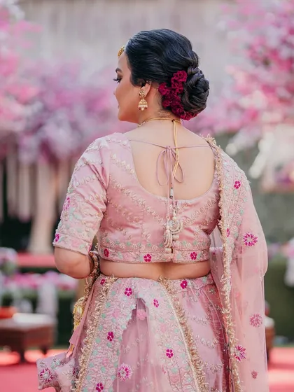 A perfect bun for a bride who dreams of a touch of nature's grace. I used these beautiful deep red flowers to create a classic floral bun that stands out against her pink lehenga.