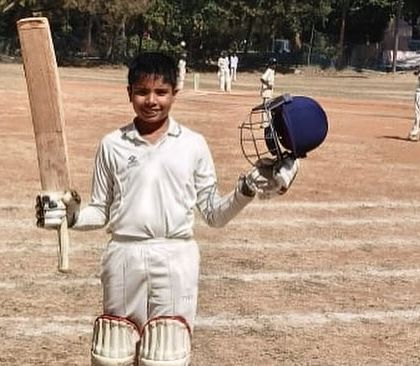 Arnav proudly holding his bat and helmet after a significant innings. This image captures the joy and satisfaction of a personal best performance.