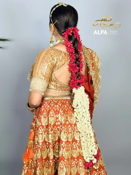 The back view of the hairstyle, showcasing a long braid adorned with fresh flowers.