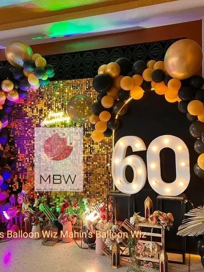 Another angle of the glamorous 60th-anniversary setup, highlighting the interplay of light on the shimmer wall and the sophisticated color scheme.
