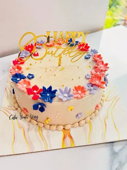 A simple, sweet, and beautiful floral cake with a variety of colorful blooms.