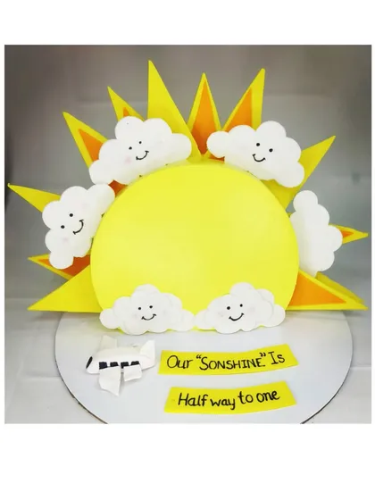 A unique top-forward cake design for a half birthday. This fresh pineapple cake is shaped like a sun, celebrating that their "son-shine" is halfway to one.
