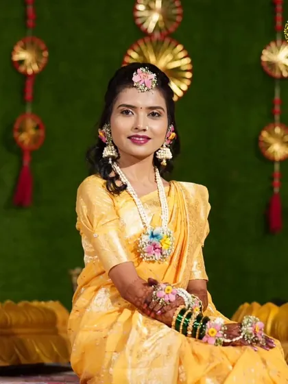 This bride looks absolutely radiant against the festive Haldi backdrop. I created this multi-colored floral jewellery set to add a playful and elegant touch to her yellow saree.