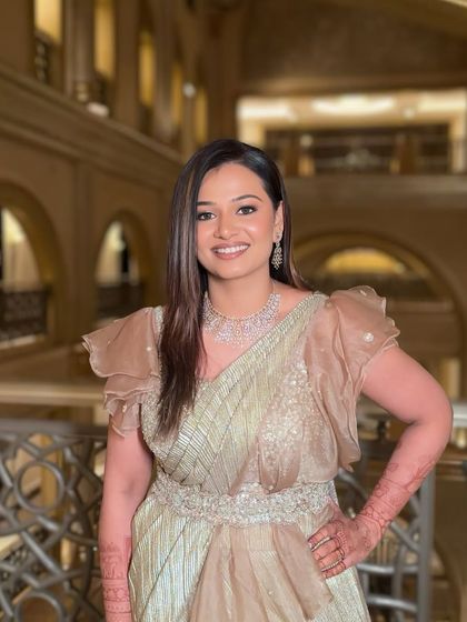 A happy and confident portrait. The bride-to-be looks stunning in her golden saree gown and sparkling makeup.