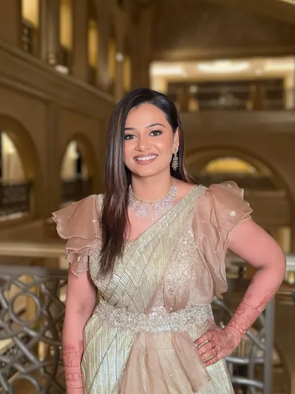 A happy and confident portrait. The bride-to-be looks stunning in her golden saree gown and sparkling makeup.