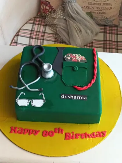 A professional and respectful cake for a doctor's 80th birthday, designed to look like a green scrub shirt with a stethoscope.