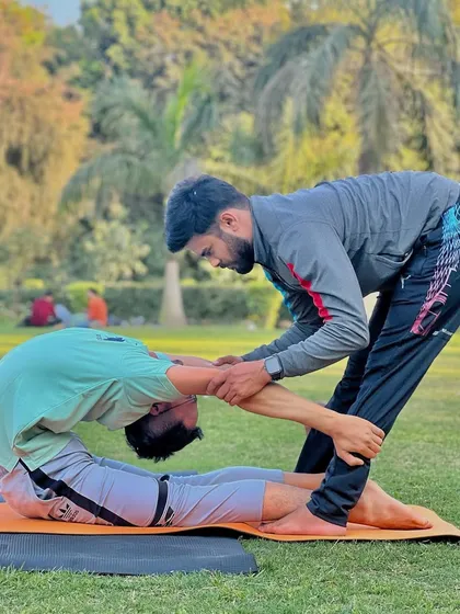 Here I am assisting a student with the Viparita Pashchimottanasana. This hands-on approach helps deepen the stretch safely and effectively.