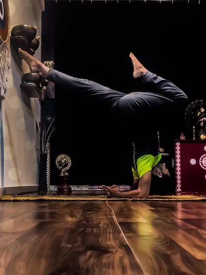 My morning practice often includes Pincha Mayurasana, the feathered peacock pose. Using the wall as a guide, I work on the split-leg variation to open my hips while building shoulder and core strength.