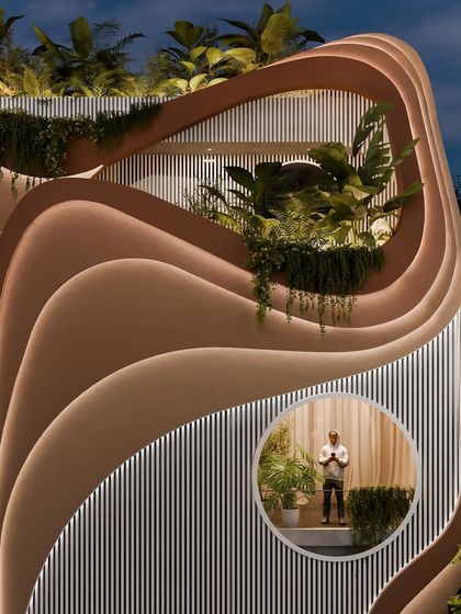 A detail shot of the "Water & Wind" facade at night, with the integrated lighting emphasizing the depth and complexity of the layered curves.