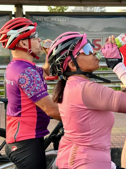 Two members sharing a drink and a laugh during a hydration break.