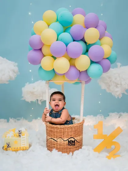 Up, up, and away! This half-birthday hot air balloon concept is one of our most popular creative themes. The pure excitement on this little one's face says it all.