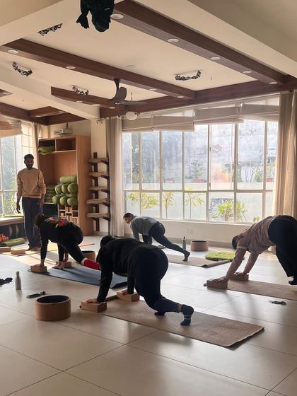 A class works on a plank variation, building core strength with the guidance of an instructor.