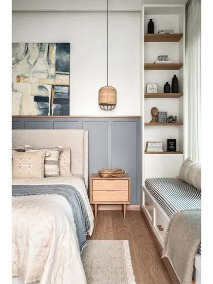 Simplicity and elegance define this master bedroom. I used MDF wainscoting on half of the bed wall, painted in a soothing grey, with the other half in pure white. This creates a calm backdrop for the light beige upholstered bed and oak side tables.