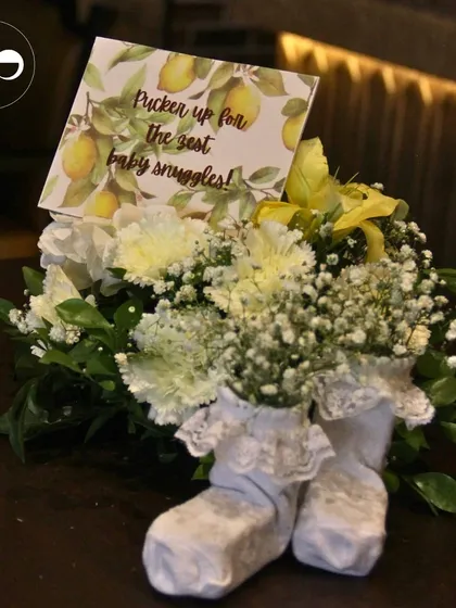It's the little details that make an event truly special. For a citrus themed shower, I created these adorable centerpieces using baby booties as a vase for fresh carnations and baby's breath, complete with a playful, themed card.