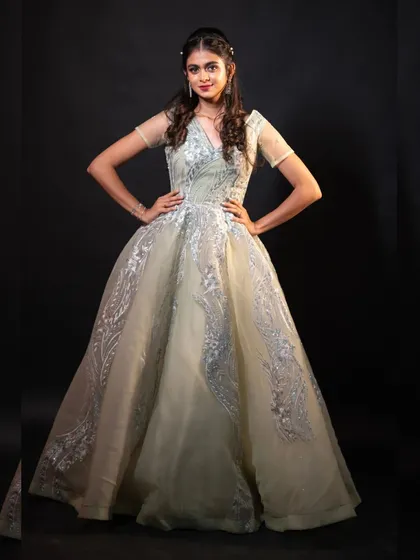 This light pista green ball gown is a fantastic choice for pre-wedding or reception-style photoshoots. Its intricate silver embroidery looks stunning against the simple black background, creating a very elegant and grand feel.
