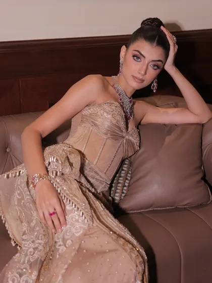 A moment of repose in the custom-made champagne gown, highlighting its intricate handwork and timeless design.