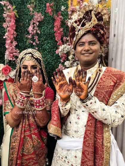 A happy wedding day moment. The bride and groom proudly show off their henna, a beautiful symbol of their union and the beginning of their new life together.