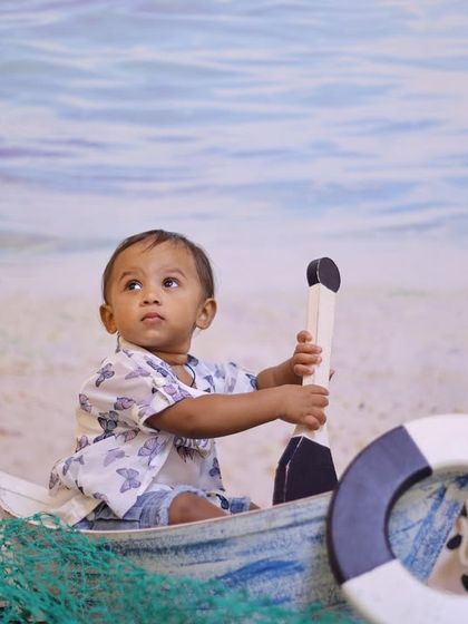 Explore our full nautical and beach-themed collection. These images showcase the variety of poses and angles possible with our boat prop, sand-colored flooring, and ocean backdrop.