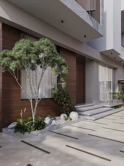 A carefully placed tree and a bed of white pebbles create a zen-like garden feature at the entrance. This detail highlights our focus on integrating natural elements into the architectural design for a sense of serenity.