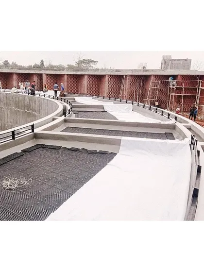 Workers laying waterproofing and drainage systems on the roof of the memorial, preparing it for the green roof installation.