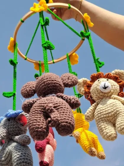 Bring the magic of the jungle to your nursery with this handmade animal mobile. Featuring a lion, elephant, and monkey, each little character contains a gentle rattle to softly engage and soothe your baby.