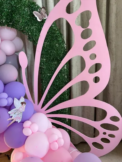 A detailed look at the large, pink wooden butterfly wing prop, a standout piece in our fairy garden theme. The intricate cutouts and placement next to the balloon arrangement showcase the quality and creativity of our custom props.