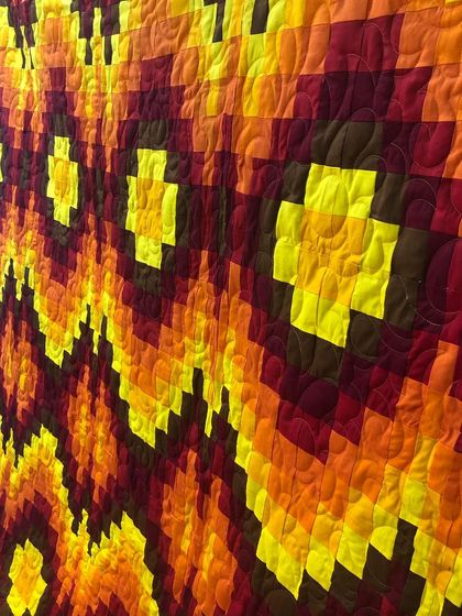 An angled shot of the Bargello quilt, highlighting the texture from our all-over quilting that complements the flowing design.