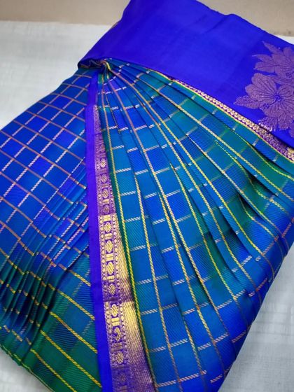 A beautiful blue and green checked saree, pleated to perfection. The contrasting colors and patterns are beautifully aligned in the folds.