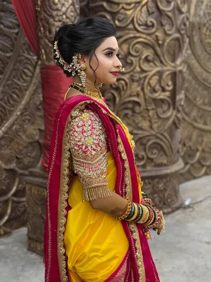 The side view of the bride, highlighting her intricate hairstyle and blouse embroidery.