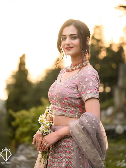 A full-body shot of the model from the music video shoot, her pastel lehenga glowing in the golden hour light.