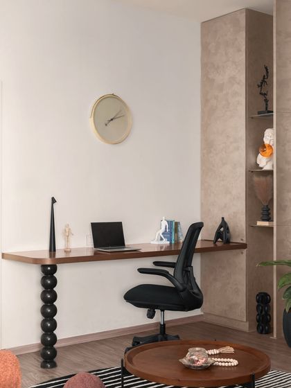 This home office nook is seamlessly integrated into the living area. The desk features a unique, sculptural leg, demonstrating how we can blend work and living spaces with artistic flair.