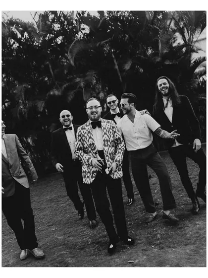 The groom and his groomsmen, looking sharp and ready for the ceremony. This candid black and white group portrait has a cool, relaxed, and timeless feel.
