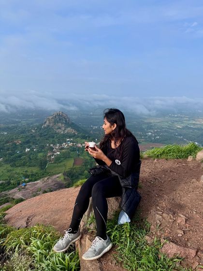 A trekker enjoying a quiet cup of tea at the top of Uttari Betta, soaking in the peaceful morning and the beautiful view.