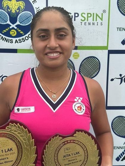 A close-up of Akanksha proudly displaying her trophies. Her success is a direct result of her unwavering commitment to the sport.