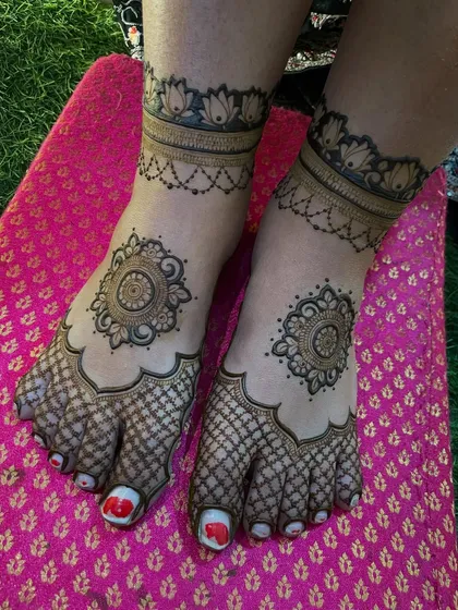 A classic foot mehendi with a central mandala and a net (jaal) pattern on the toes. This is a timeless design that is perfect for any occasion.