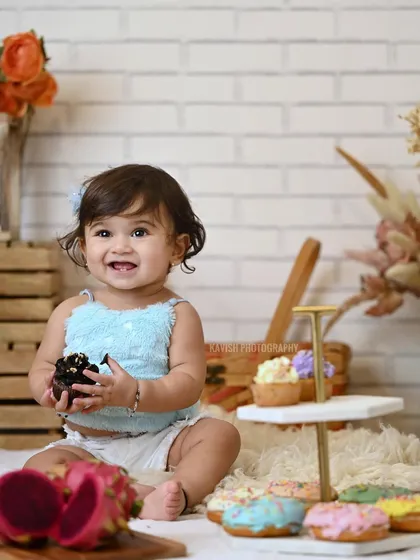A bright and happy smile from the baby girl in this sweet studio portrait.