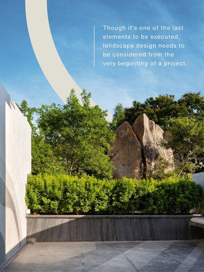 A shot of a dramatic rock formation in a garden, with text explaining that landscape design needs to be considered from the very beginning of a project. This emphasizes the importance of integrated planning.