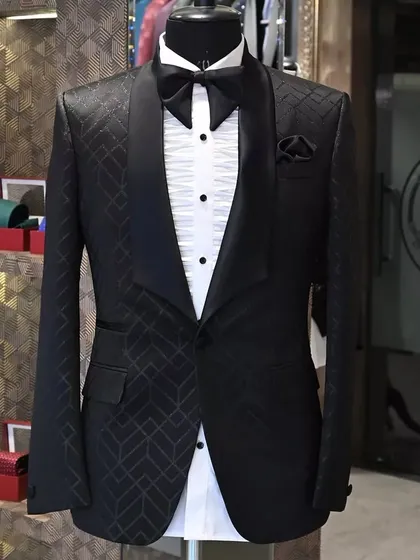 A mannequin display of the black tuxedo with a geometric pattern. This showcases the clean lines and sharp tailoring that I ensure in every piece.