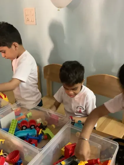 Younger children explore basic engineering concepts by sorting through and connecting Duplo and other large building blocks.