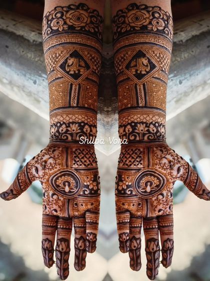 A full bridal design extending up the arms, featuring elephants and other traditional motifs.