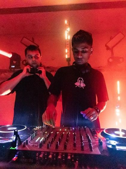 The stage is set with Pioneer DJ equipment and dramatic laser lighting. This is the view from behind the console, where artists craft the sound for a packed room.