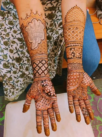 Personalization can be bold and central to the design. For this bride, we featured the initial 'M' inside a royal, crown-like frame on one arm, with a contrasting architectural dome pattern on the other.