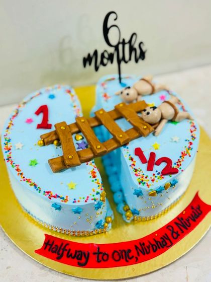 "Halfway to one!" A creative half-cake design for a 6-month celebration, featuring two babies on a bridge connecting the two halves.