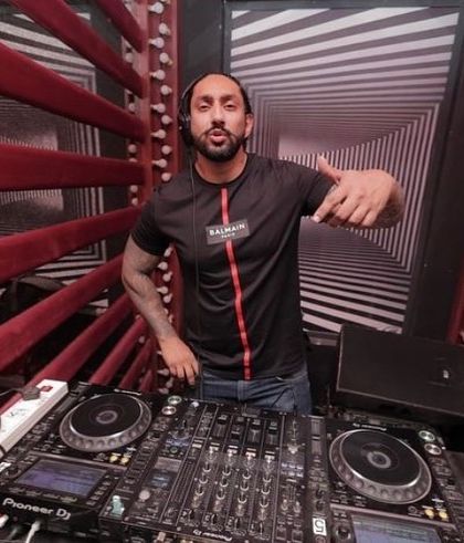 Posing for a photo from the DJ console. My enthusiasm is contagious, and I bring that positive energy to every single gig.