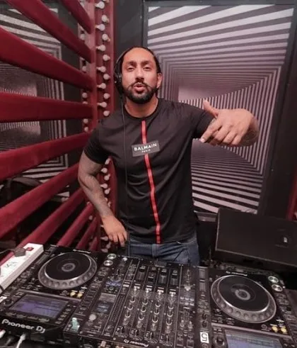 Posing for a photo from the DJ console. My enthusiasm is contagious, and I bring that positive energy to every single gig.