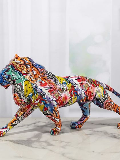 A walking lion sculpture is reimagined with a vibrant, graffiti-inspired pattern. This piece captures the power of the animal with the creative energy of street art, perfect for an eclectic interior.