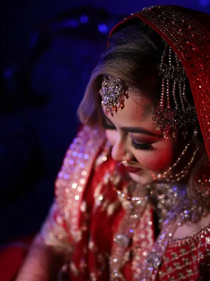 A stunning bridal portrait that showcases our expertise in using dramatic lighting to highlight the bride's elegance and intricate details. This shot captures her quiet confidence and beauty on her special day.